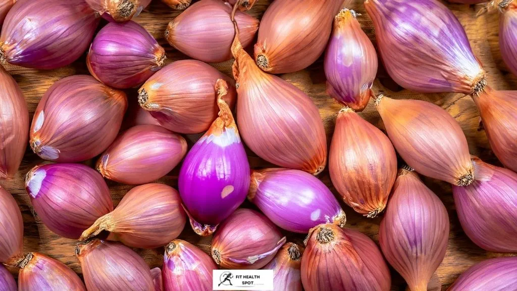 An image of fresh shallots with their unique shape and characteristic skin. They fall in size between onions and garlic and can range in color from golden brown to purplish hues.